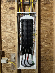An open residential electrical breaker panel with organized wiring installed by RAD-WIRE ELECTRIC, LLC in Manchester, NH.