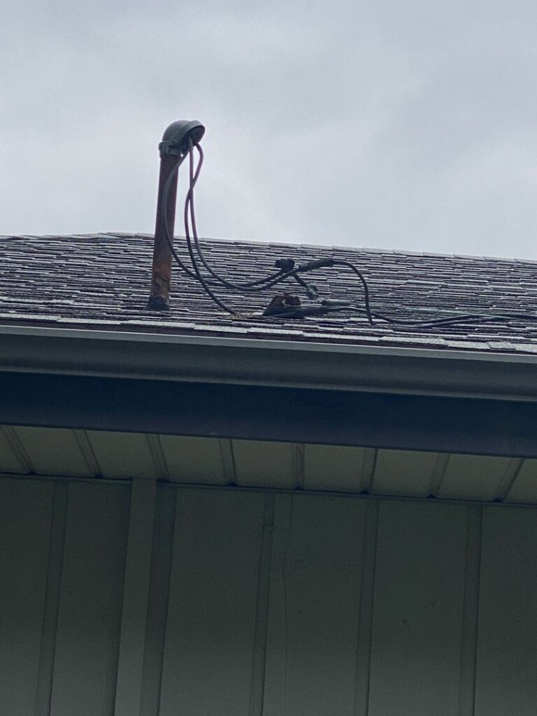An electrical mast and service wires on a residential roof, demonstrating the exterior electrical work provided by AA Electric Contractors in Chicago, IL.