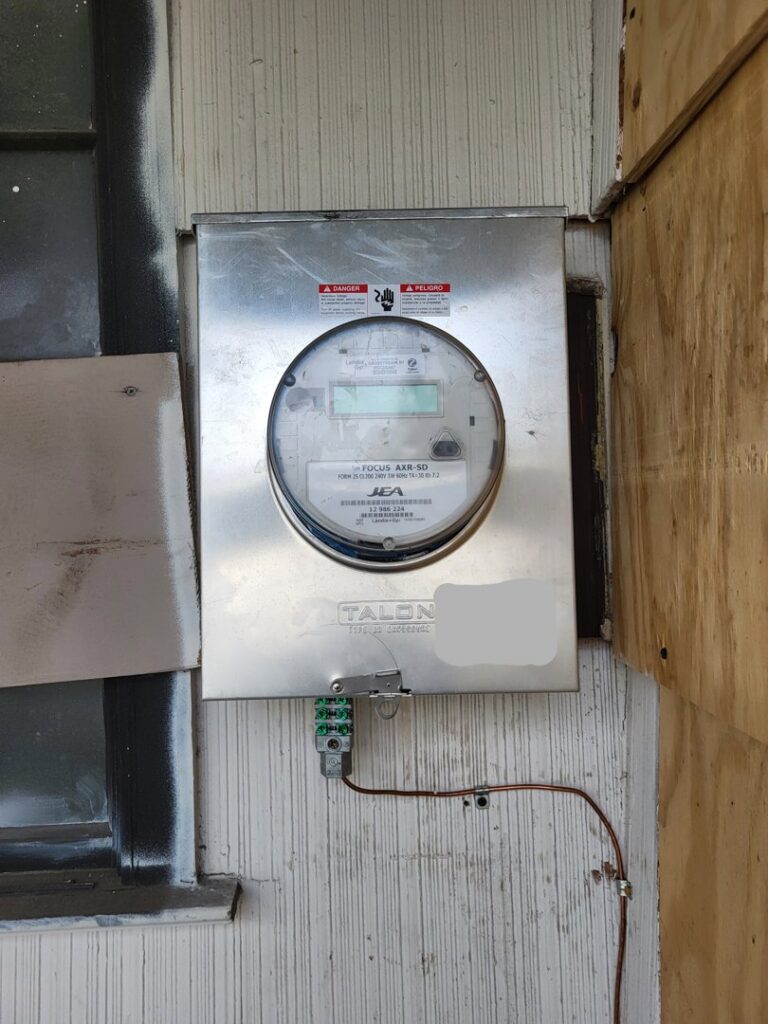 A residential electrical meter box on the exterior of a home, installed by Ozzy Electric in Jacksonville, FL.