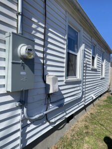 The exterior of a residential home showing an electrical meter and conduit installed by Peak Electric in Mount Washington, KY.