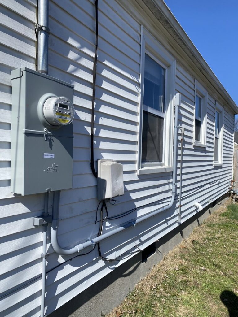 The exterior of a residential home showing an electrical meter and conduit installed by Peak Electric in Mount Washington, KY.