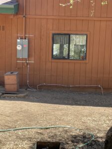 Residential electrical meter and grounding wire installation on a house exterior by Ernco Electric Inc. in Fresno, CA.