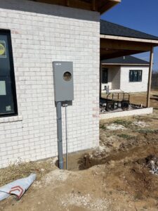 A newly installed residential electrical meter and conduit on the exterior of a brick home by Ace Electrical Services LLC in Owensboro, KY.