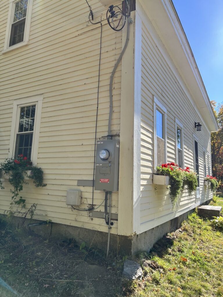 An exterior view of a residential electrical meter and conduit installation by Daigle Electric in Middleboro, MA.