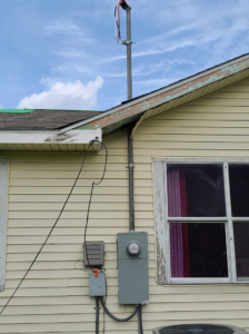 A residential electrical meter and service mast installed on the side of a house by ECS. Electrical Contracting Services LLC in Lake Charles, LA.