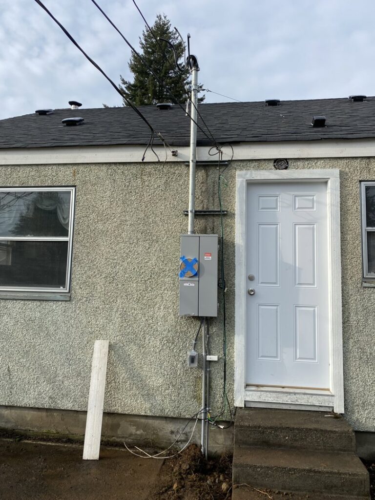 A residential electrical meter and service entrance on a house, installed by Good Contact Electric, LLC in Tacoma, WA.