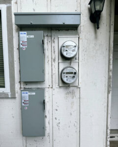 Residential electrical meters and service panels installed on a building exterior by Mountain Coast Electric in Salem, OR
