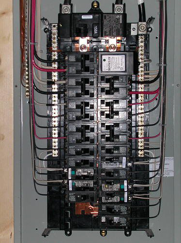 An open residential electrical panel with circuit breakers and wiring, serviced by Electric Experts Inc in Caldwell, ID.