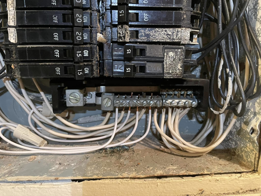 An open residential electrical panel with circuit breakers and wiring, serviced by Charging Rhino Electric in Mobile, AL