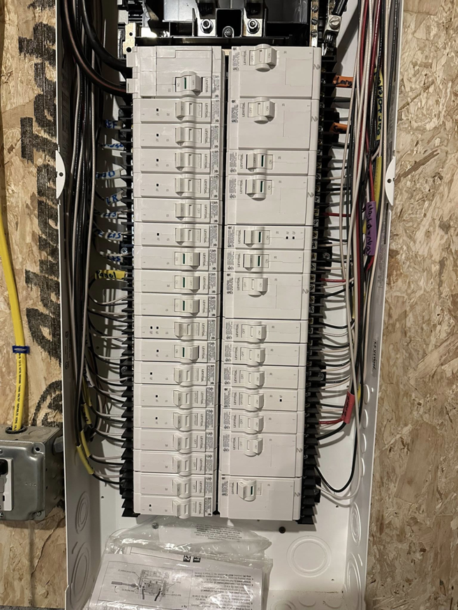 An open residential electrical panel with circuit breakers installed by Bat Juice Electric LLC in Manchester, NH