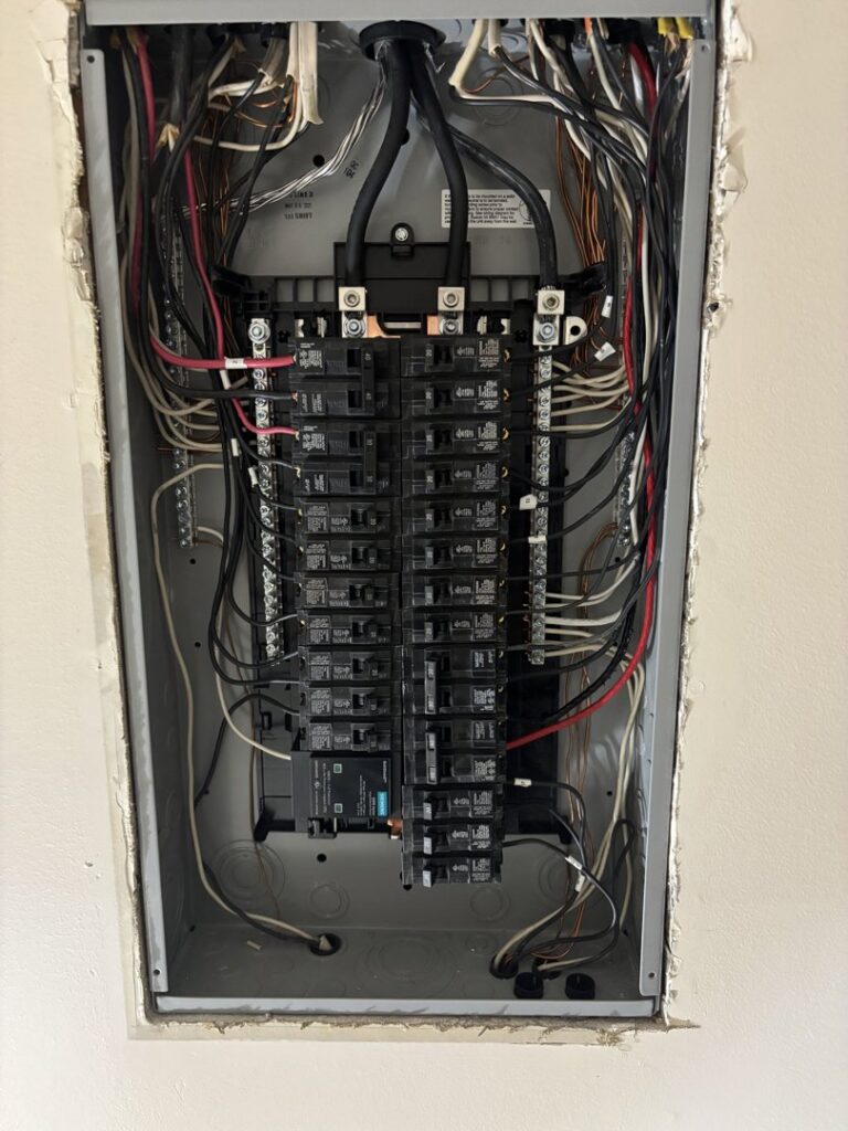 Detailed view of a residential electrical panel with organized wiring and circuit breakers by Regal Electrical Services in West Jordan, UT.