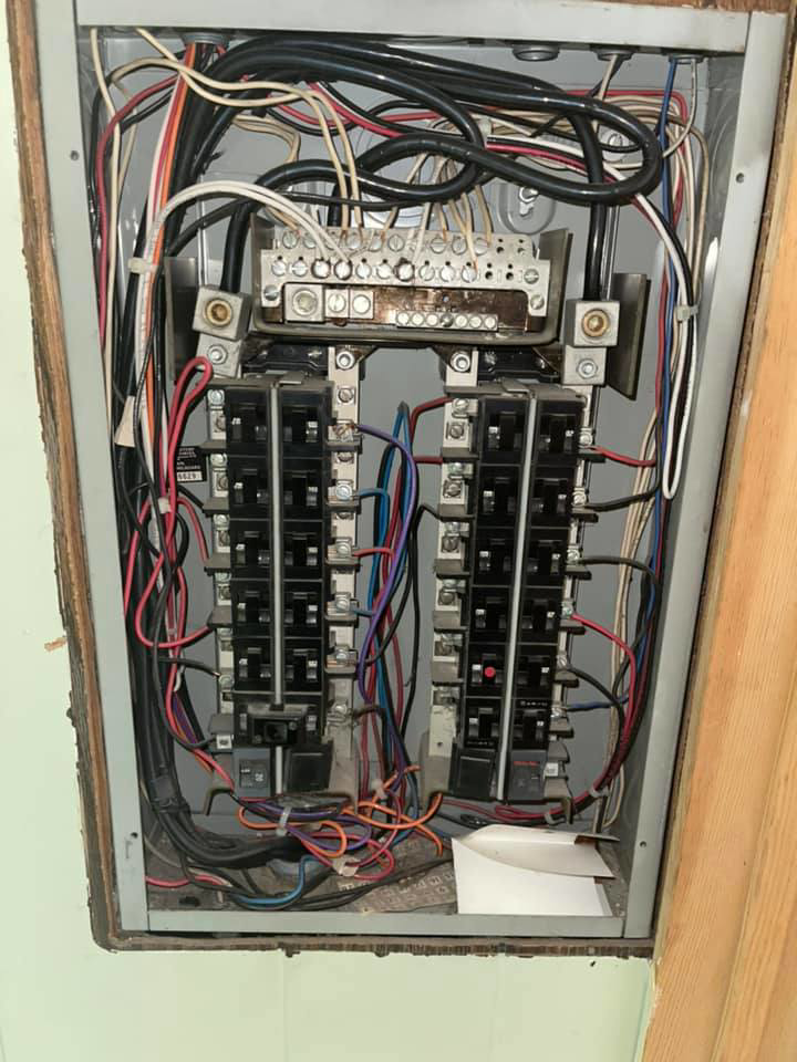 Close-up view of a residential electrical panel with complex wiring and circuit breakers by Vera Electric in Aurora, IL.
