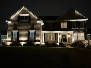 A residential house beautifully illuminated by exterior accent lighting at night by K E Troutman Electrical Contractor in Newark, DE.