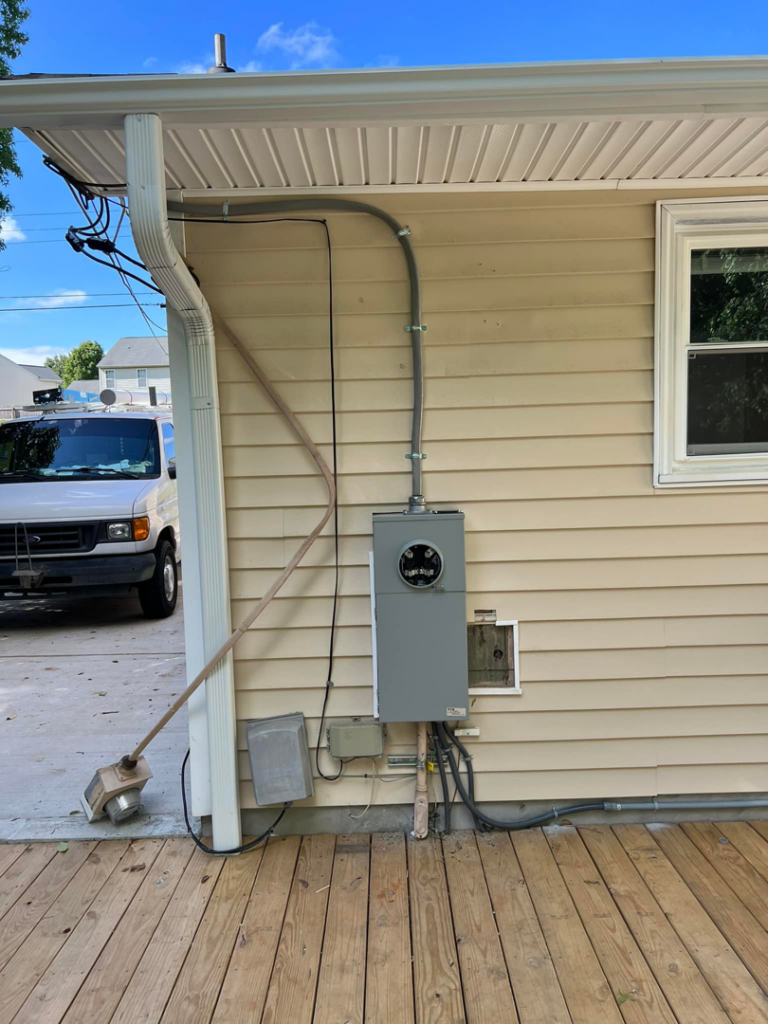 An exterior electrical service panel and conduits on a residential home, installed by Kaufman Electric in Greensboro, NC.