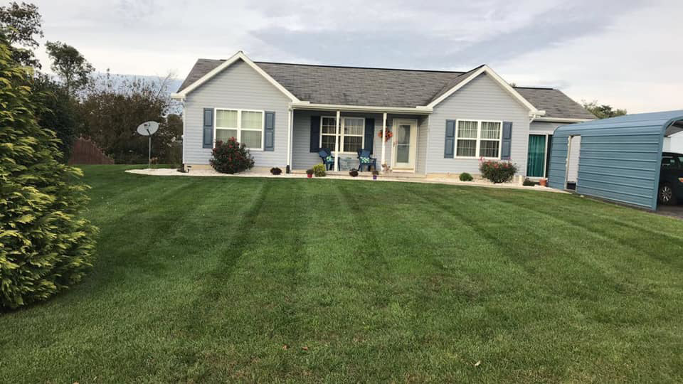 A well-maintained residential front lawn with clean mowing stripes, provided by Clean Cuts Lawn Care in Cavetown, MD.