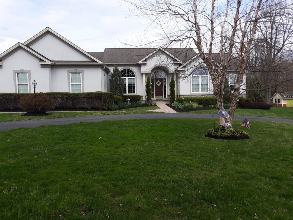 A residential front yard with fresh mulch and well-maintained landscaping by John's Lawn Care Service's in Saint Petersburg, FL