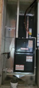 A Goodman residential furnace and air handler unit with ductwork installed in a framed closet by Integrity Heating And Air LLC in Nampa, ID