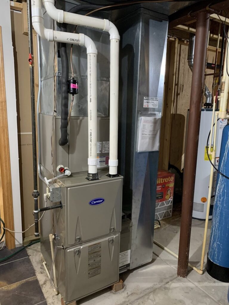 A residential furnace system with ductwork and piping, maintained by Tom's Heating Service in Waukesha, WI.