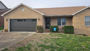 A residential house featuring a dark brown garage door, installed by A+ Garage Door Repair in Evansville, IN.