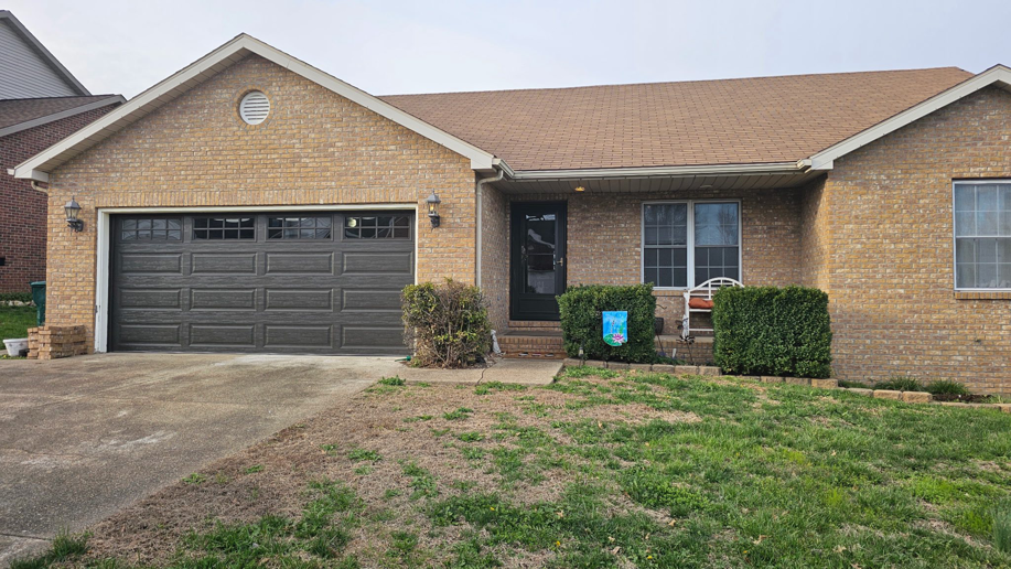 A residential house featuring a dark brown garage door, installed by A+ Garage Door Repair in Evansville, IN.