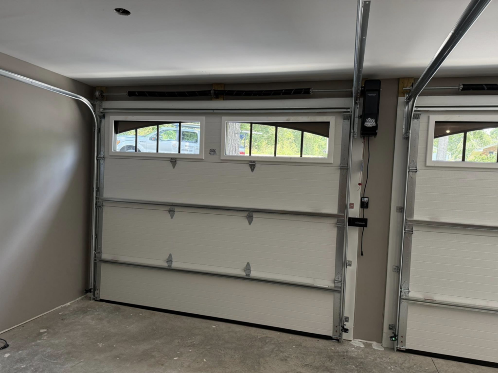Two newly installed white residential garage doors with windows by Guest Garage Door Company in Lexington, KY.