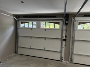 Two newly installed white residential garage doors with windows by Guest Garage Door Company in Lexington, KY.