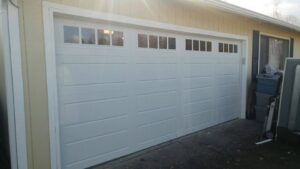 A newly installed white paneled residential garage door with top windows by Xpress Doors LLC in Salem, OR