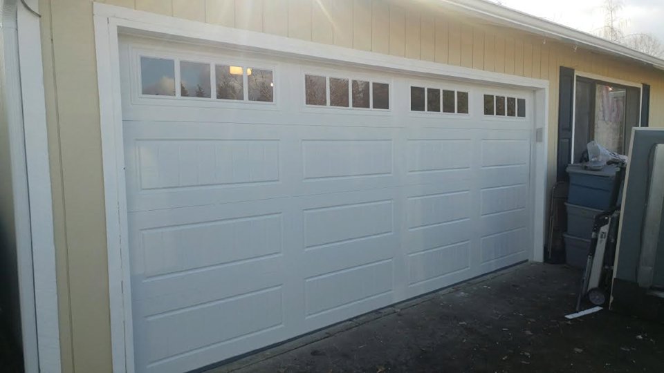 A newly installed white paneled residential garage door with top windows by Xpress Doors LLC in Salem, OR