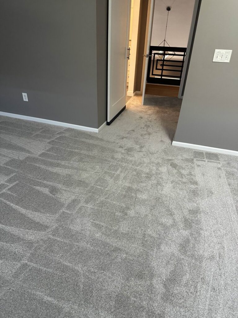 A newly installed grey carpet in a residential room by The Flooring Supplies Co. in Livonia, MI.