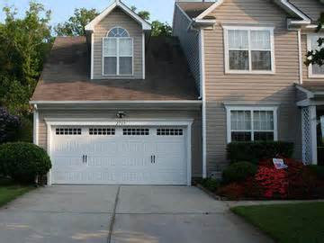 A residential house featuring a single white garage door, a service provided by Precision Garage Door of Charleston in North Charleston, SC.