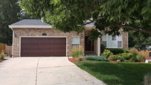 A residential house featuring a stylish brown garage door installed by Million Garage Door Services in Colorado Springs, CO.