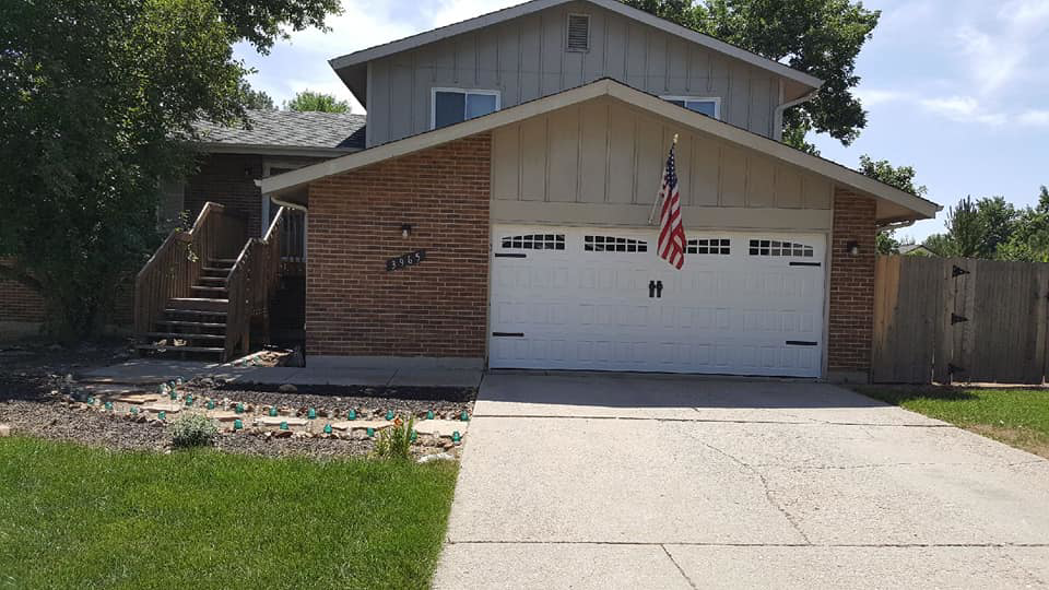 A residential house featuring a newly installed white garage door by Million Garage Door Services in Colorado Springs, CO.
