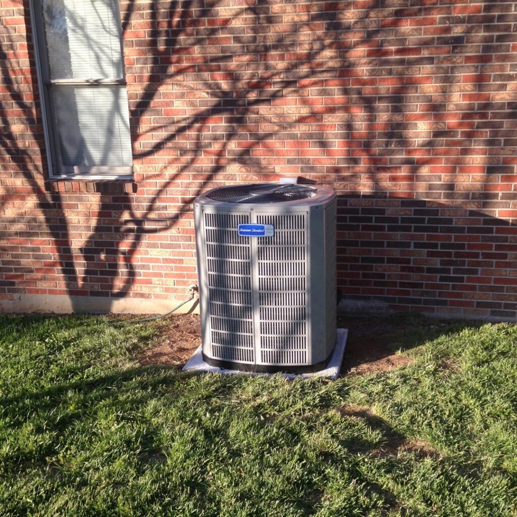 A residential HVAC condenser unit installed outside a brick home by AirTemp Heating & Cooling in Nashville, TN.