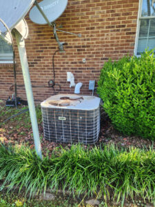 An outdoor residential HVAC condenser unit next to a brick house, ready for service by Bama Air Systems in Cullman, AL.