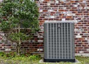 A residential outdoor HVAC condenser unit installed by Target Temp, LLC next to a brick wall in Houma, LA.