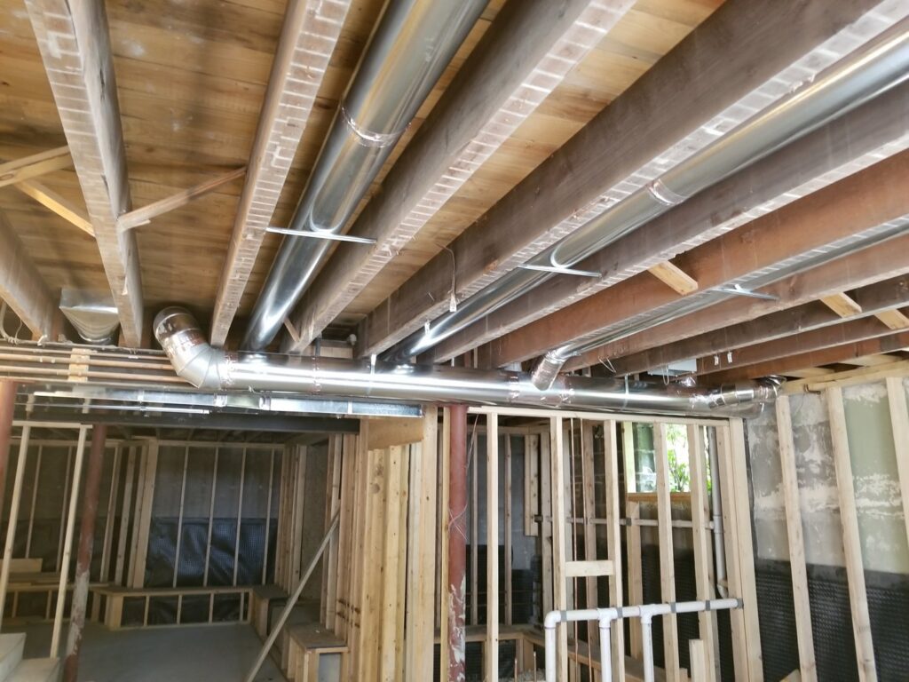 Residential HVAC ductwork installation in an unfinished basement by AccuMax Incorporated in Aurora, IL.