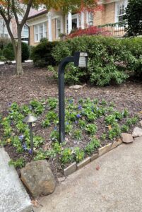 A residential keypad gate entry system installed in a landscaped garden area by Gates Contractors in White, GA.
