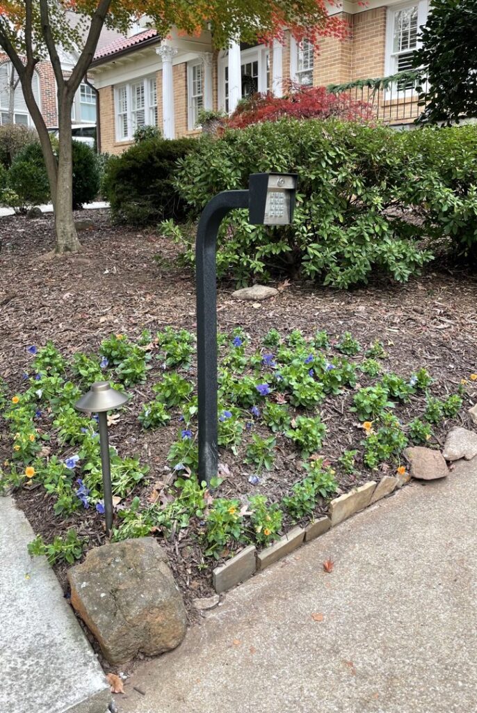 A residential keypad gate entry system installed in a landscaped garden area by Gates Contractors in White, GA.