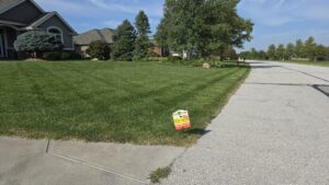 A neatly maintained residential lawn featuring a Pro Turf & Pro Pest Solutions sign, indicating professional service in Omaha, NE.