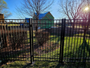 A black metal fence with a gate installed in a residential area by Green Acres Fence Co in Salina, KS.