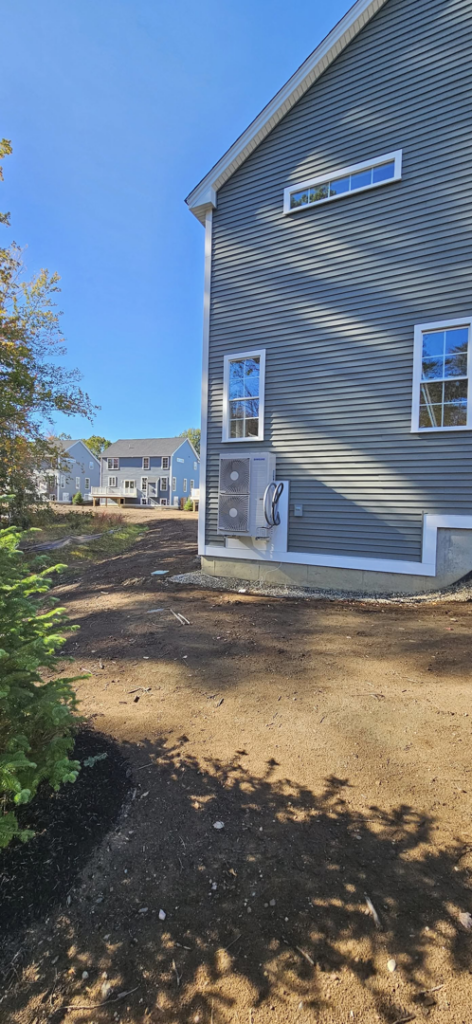 A residential mini-split system outdoor unit installed on the exterior of a house by Blue's Mini Splits LLC in Dover, NH