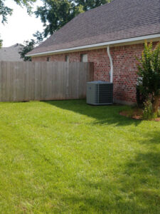 A residential outdoor air conditioning unit installed next to a brick house, serviced by ARKLA AIR LLC in Springhill, LA.