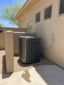 A residential outdoor AC unit installed next to a home by Ash Cooling & Heating in Mesa, AZ.