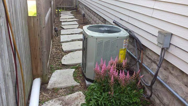 A residential outdoor air conditioning unit with landscaping by Complete Comfort Heating & Cooling in Kenosha, WI.