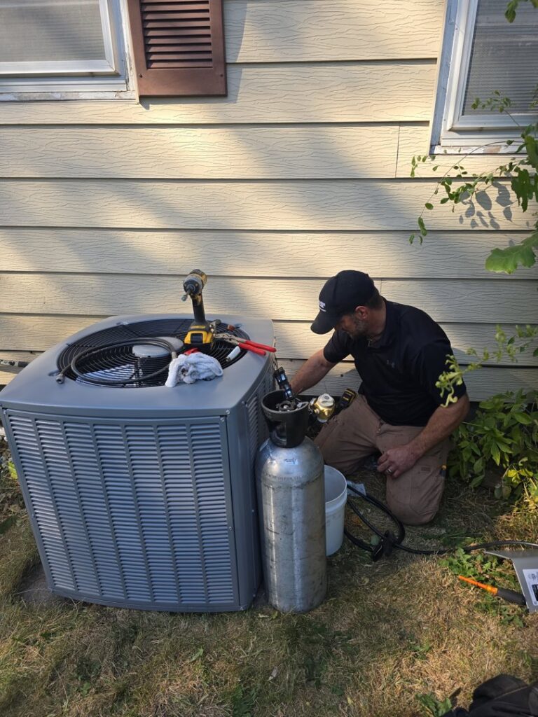 A residential outdoor air conditioning unit installed next to a house, providing cooling services by 24/7 Heating & Air, LLC in Grand Island, NE.