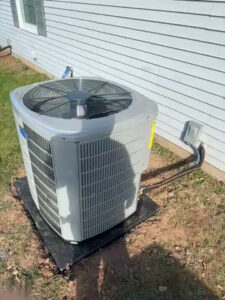 A residential outdoor air conditioning unit installation next to a house by Aire Serv of Rochester, NY