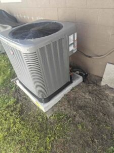 A residential outdoor AC unit installed on a concrete pad by QUICK AIR USA in Orlando, FL.