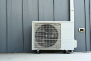 A residential outdoor air conditioning unit installed next to a building by Terry Allen Plumbing & Heating in Flint, MI.
