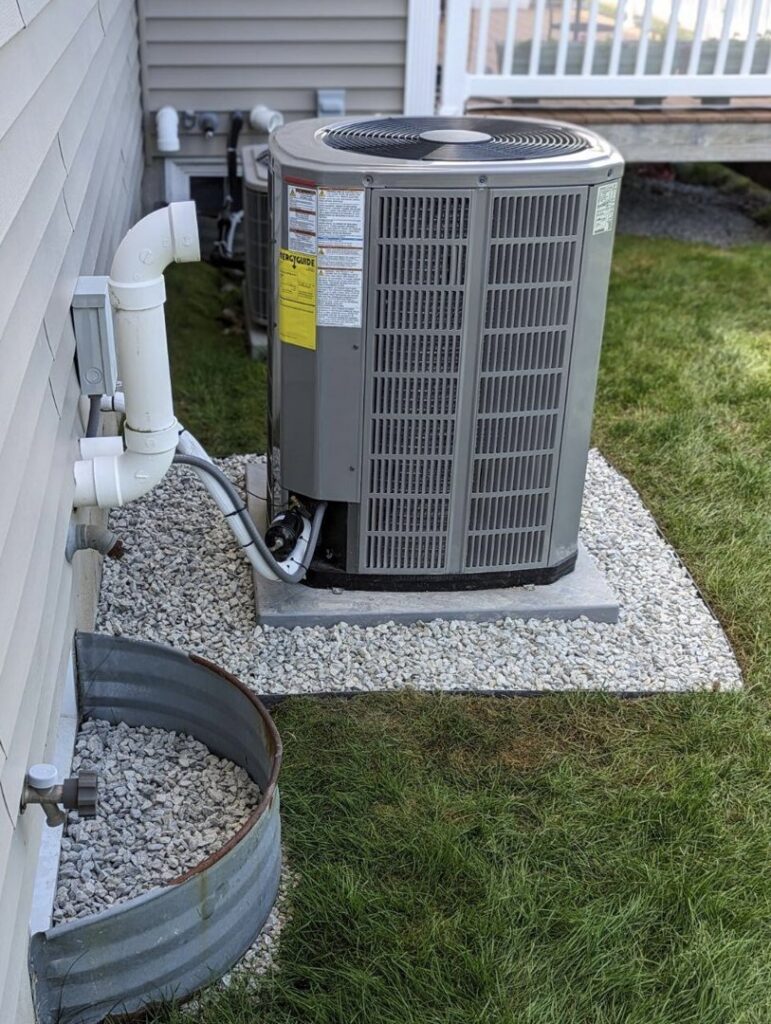 A residential outdoor air conditioner unit installed on a gravel bed by PureTemp Heating and Cooling in Salem, NH.