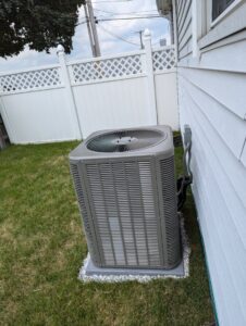 A residential outdoor condenser unit installed on a concrete pad by WARM Global HVAC in East Providence, RI